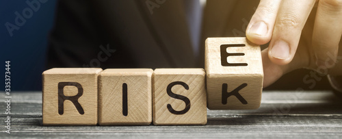 Businessman changes wooden blocks with the words Risk and Rise. Business risk management and growth performance. Risks assessment. Planning strategies and achieving goals. photo
