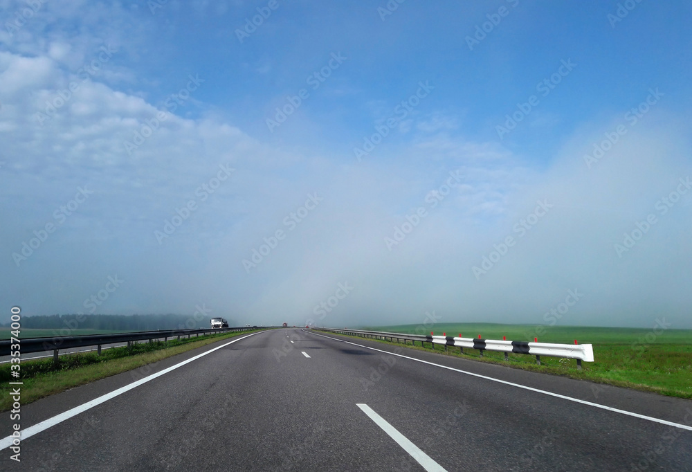 The track that goes into the distance. Cloudy sky and fog on the highway.