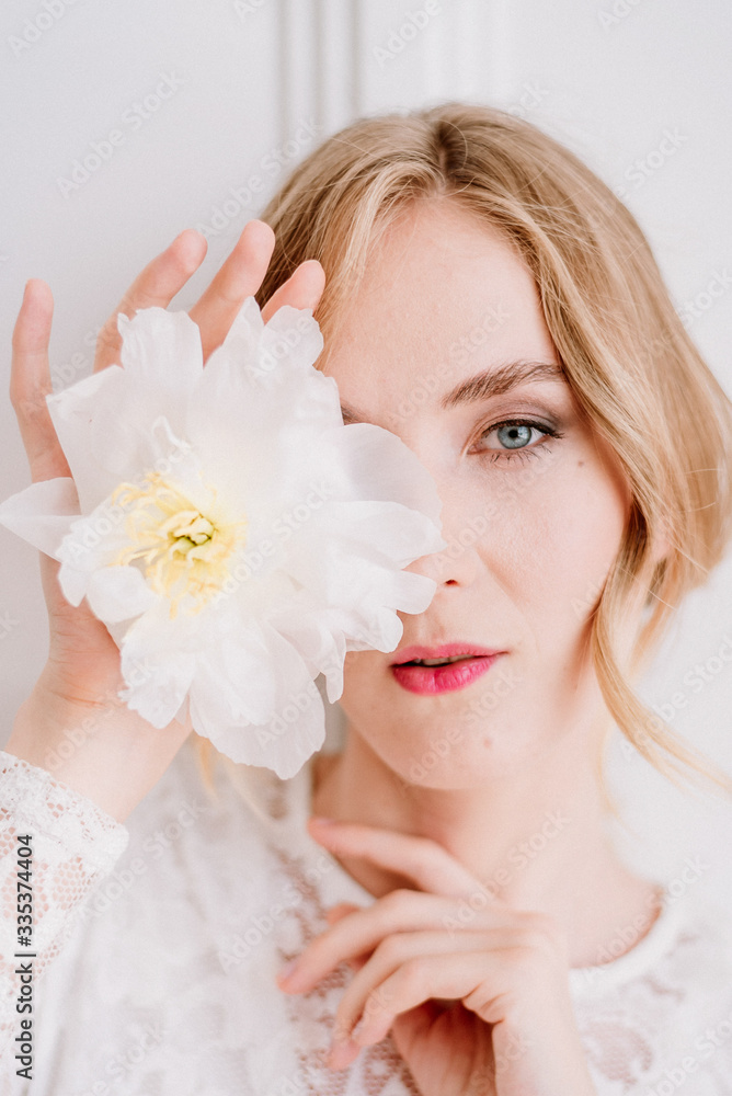 Beautiful bride in a white laced dress and wedding bouquet is preparing for wedding ceremony in hotel room. Bride getting ready. Artwork Beautiful bride in a white laced dress and wedding bouquet is preparing for wedding ceremony in hotel room. Bride getting ready. Artwork