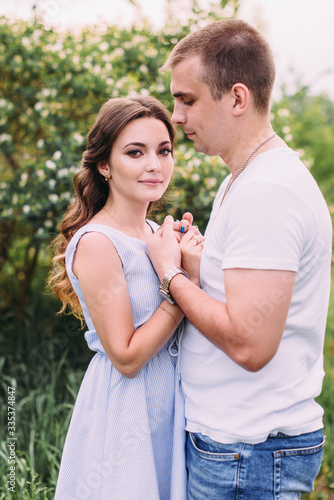 Happy young couple walks in the park, love story. The relationship of a guy and a girl, a photo shoot in nature © Илья Антохин