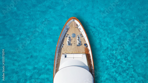 Aerial drone top down photo of luxury exotic yacht nose with wooden deck anchored in paradise turquoise bay © aerial-drone