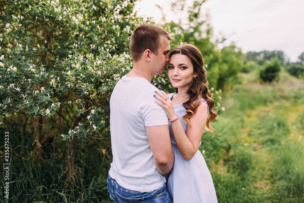 Happy young couple walks in the park, love story. The relationship of a guy and a girl, a photo shoot in nature Happy young couple walks in the park, love story. The relationship of a guy and a girl, a photo shoot in nature