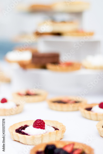 tartaletas y pasteles de frutas en mesa blanca  photo