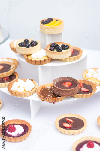 tartaletas y pasteles de frutas en mesa blanca  photo