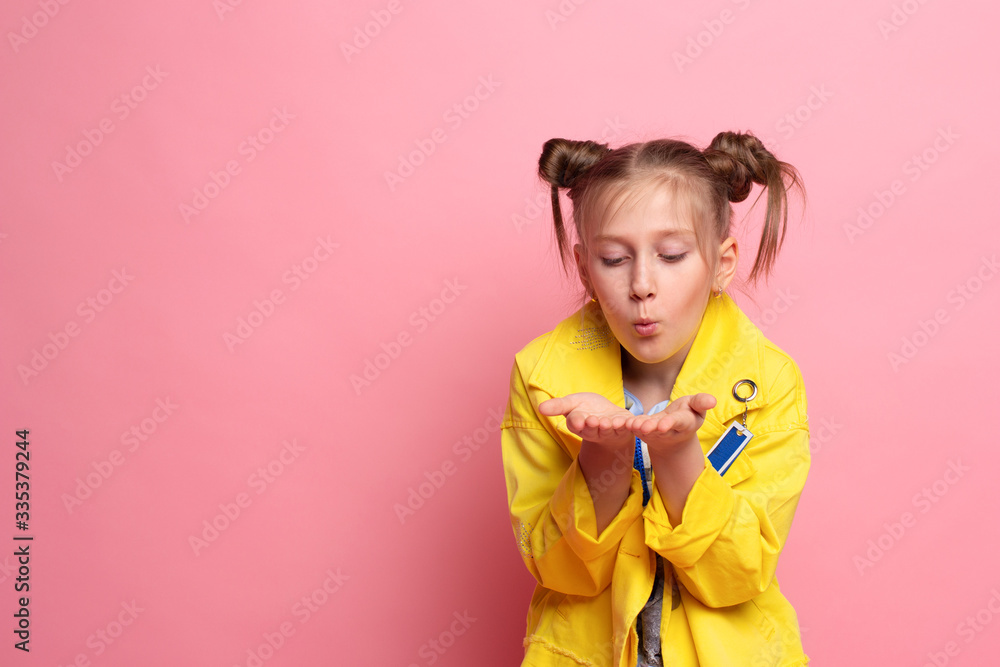 Pretty girl blowing on palms with hairstyle on pink background. empty space. pleasant feelings concept. Pretty girl blowing on palms with hairstyle on pink background. empty space. pleasant feelings concept.