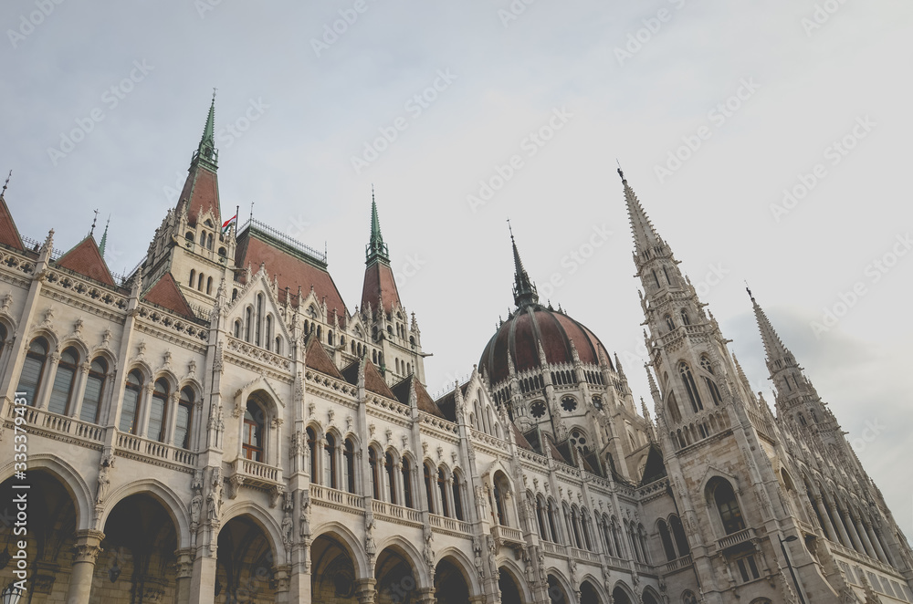 Building of the Hungarian Parliament Orszaghaz in Budapest, Hungary. The seat of the National Assembly. House built in neo-gothic style. Sunset light shining on the building. Horizontal photo