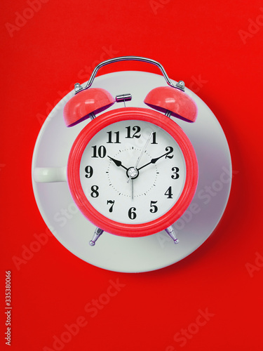 cup of clock. red retro alarm clock on red background. Round red alarm clock. ten hours ten minutes of the morning time to get up to wake up and have breakfast morning or evening jog to go to work