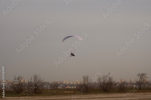 Paraglider on the lake over a sandy beach.