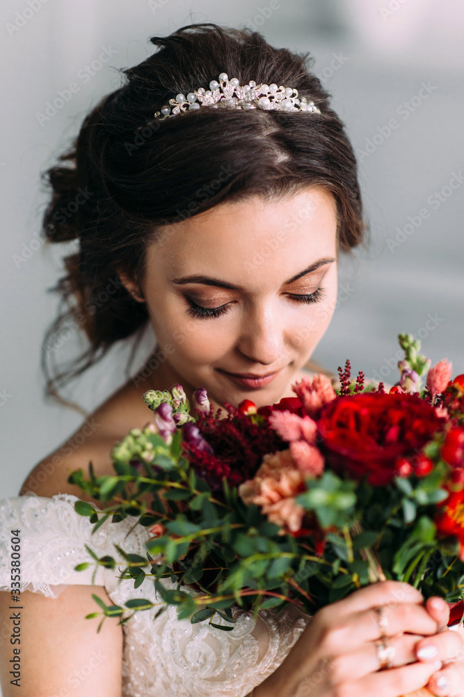 Portrait of a bride in a beautiful wedding dress with a wedding bouquet of peony roses