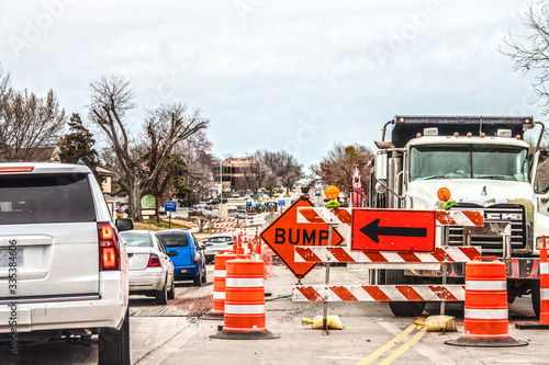 Trucks and road equipment on road with one lane blocked to horizon in urban area an cars navigation the construction