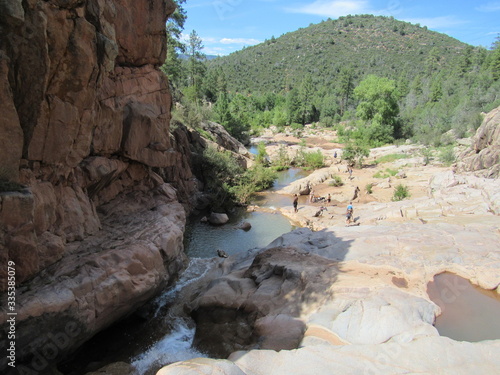 View over the Ellison Creek waterfall with unrecognizable tourists and locals below on the Water Wheel Falls hiking trail in Payson, Arizona photo