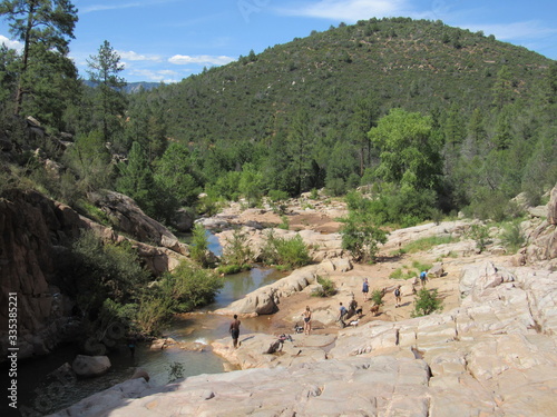 View over the Ellison Creek waterfall with unrecognizable tourists and locals below on the Water Wheel Falls hiking trail in Payson, Arizona photo