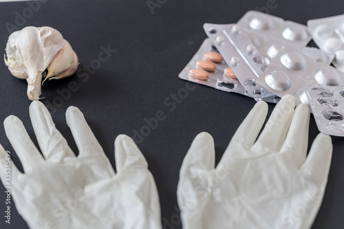 medicine gloves and garlic on a black background