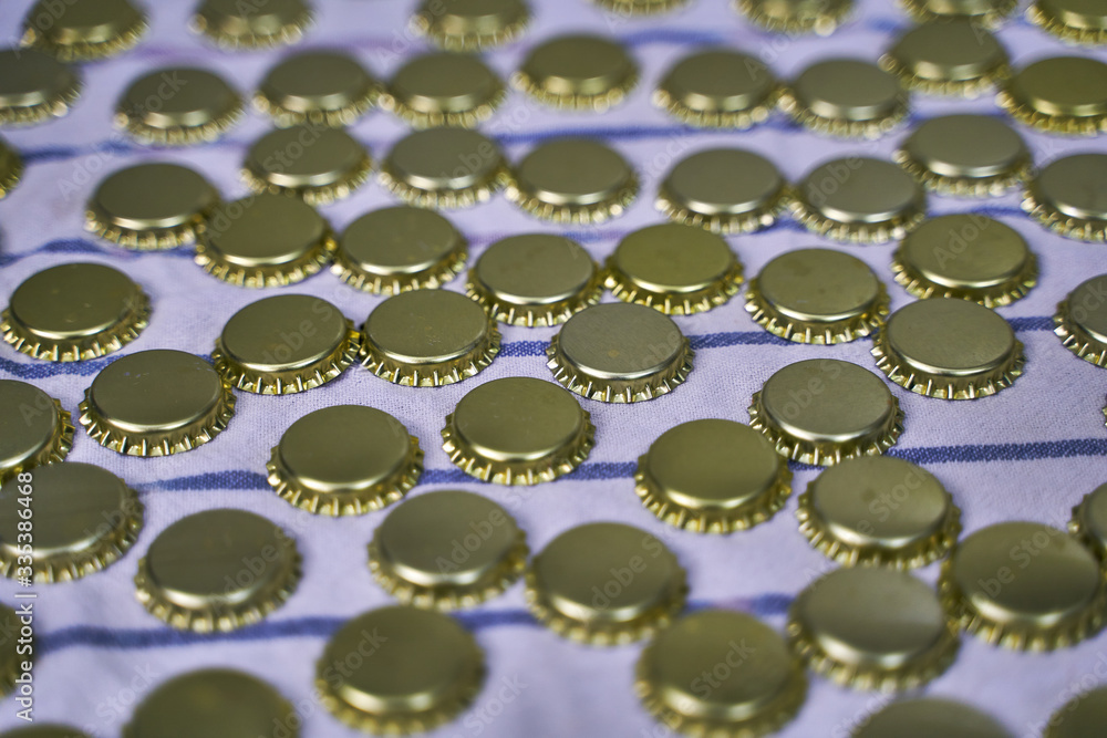 Metal beer caps in line on cloth in a brewery Metal beer caps in line on cloth in a brewery