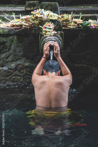 Portrait from behind of a man praying in the holy spring of Tirta Empul, Bali  - Homme de dos priant dans une source d'eau sacrée