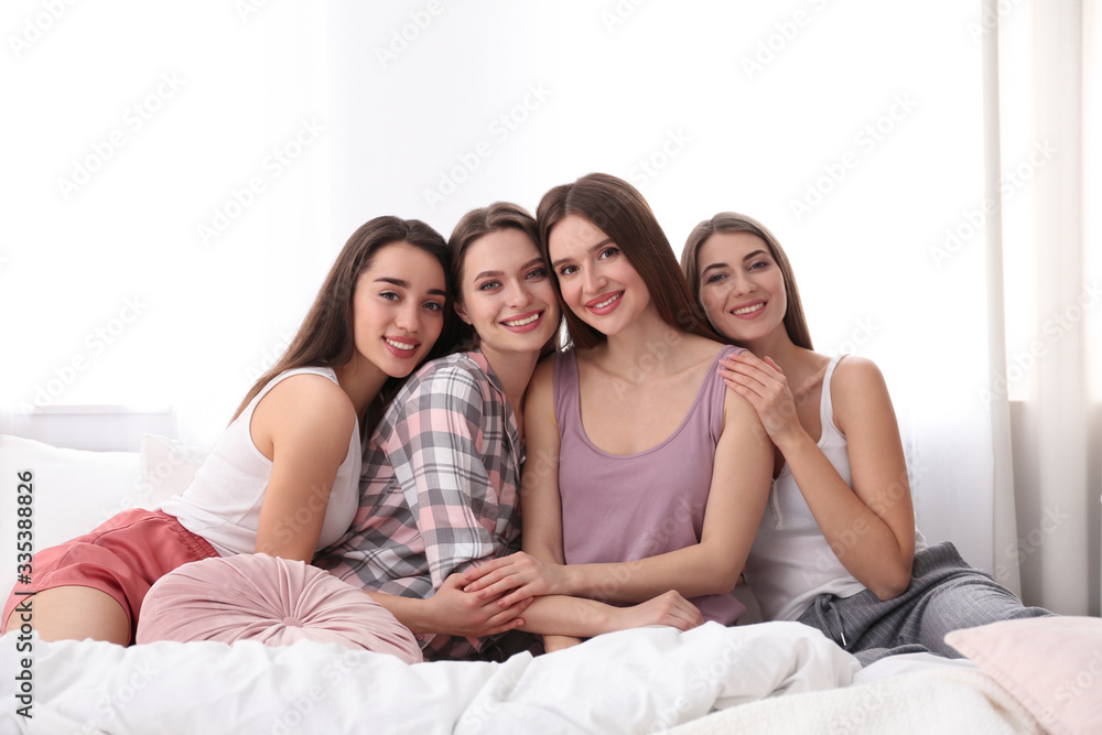 Beautiful young ladies on bed at pamper party. Woman's Day Beautiful young ladies on bed at pamper party. Woman's Day