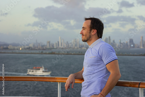 Handsome man aboard a cruise ship. Portrait of a smiling man on a background of a big city.