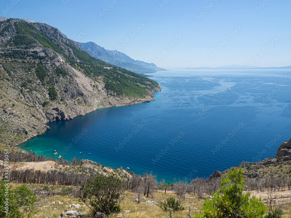 Mar y montaña preciosos acantilados acabando en un agua transparente turquesa y azul en la costa croata, en verano de 2019