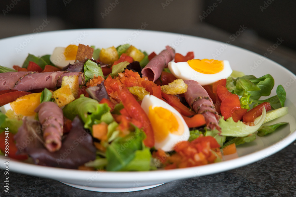 Gemischter Bio Salat Teller mit Tomaten, Eier, Schinken und Croutons, Produktbild Gemischter Bio Salat Teller mit Tomaten, Eier, Schinken und Croutons, Produktbild