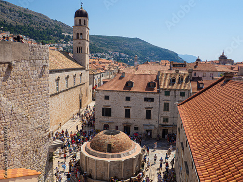 Vistas de tejados rojos y el campanario en la ciudad de Dubrovnik con mucha gente paseando, en Croacia, verano de 2019