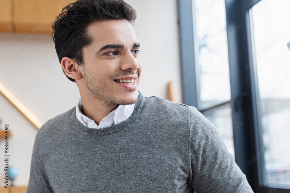 Portrait of businessman looking away and smiling in office Portrait of businessman looking away and smiling in office
