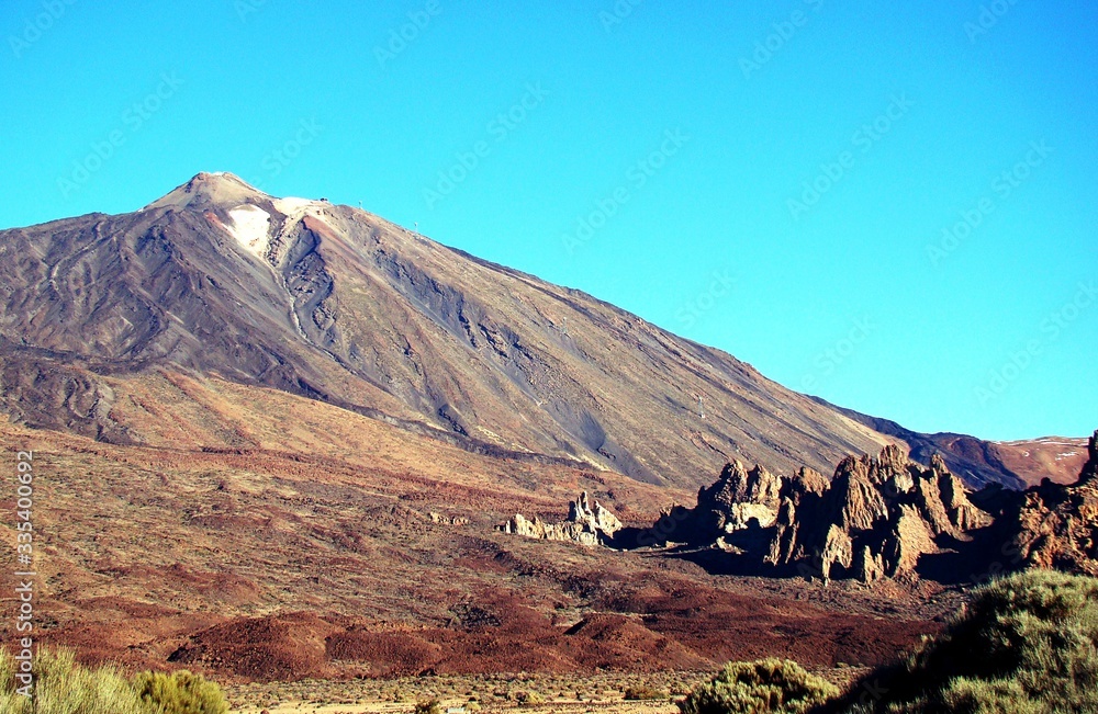 View of the Teide volcano on the island of Tenerife. snowy mountain top. lava fields at the foot of the volcano