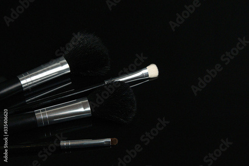 make up brushes lying on black glass table. photo with selectiv focus, low key photo