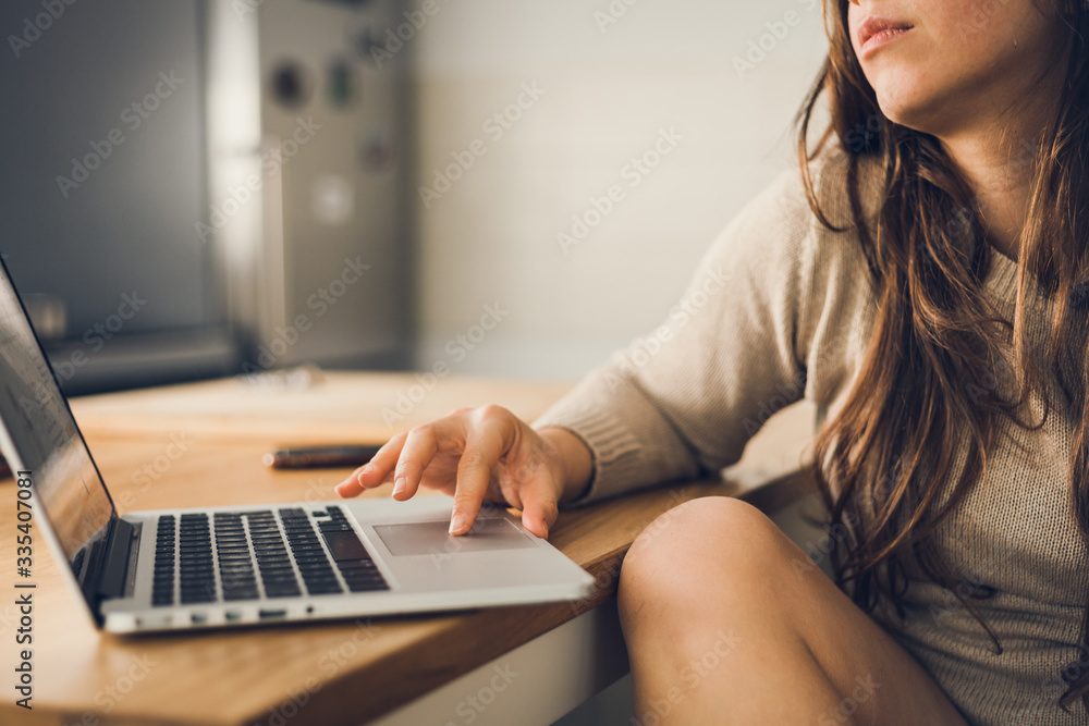 Young woman working on laptop computer at home due to corona virus pandemic. Working remotely concept. Young woman working on laptop computer at home due to corona virus pandemic. Working remotely concept.