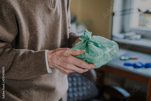 Cheerful senior holding home-delivered meal, quarantine during pandemic Covid-19