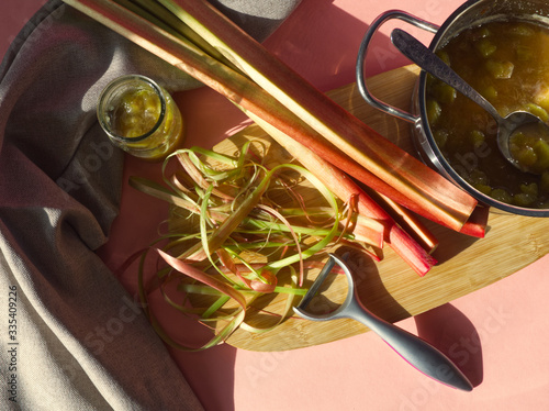 Obraz na plátne Rhubarb jam, stalks and peel on wooden and pink background
