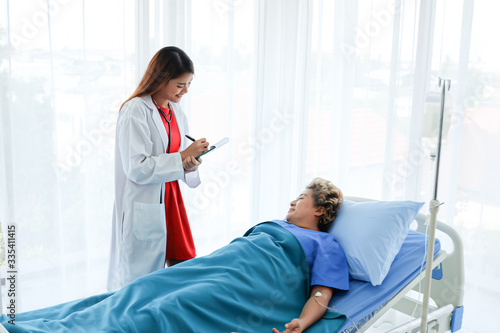 Asian doctor having checkup for a senior patient taken by soft focus technique