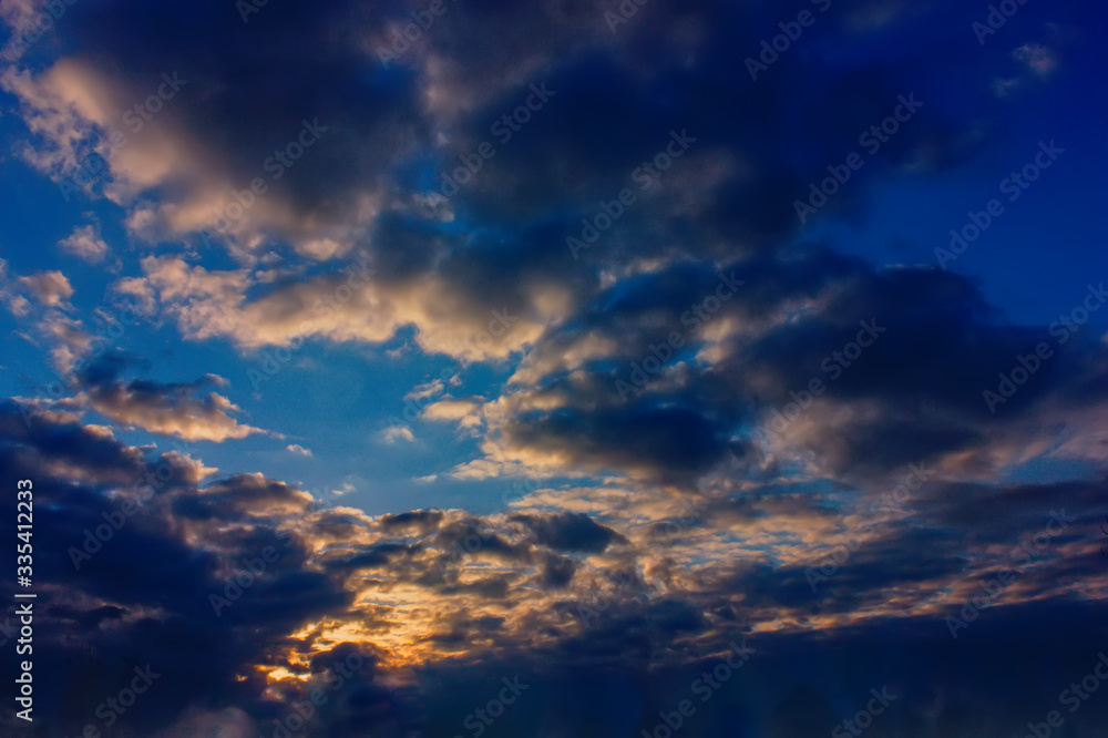 The sky at sunset. Cumulus clouds lit by the rays of the setting sun.