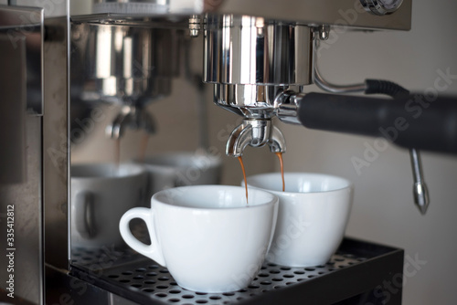 Preparing two cups of coffee on an espresso machine.
