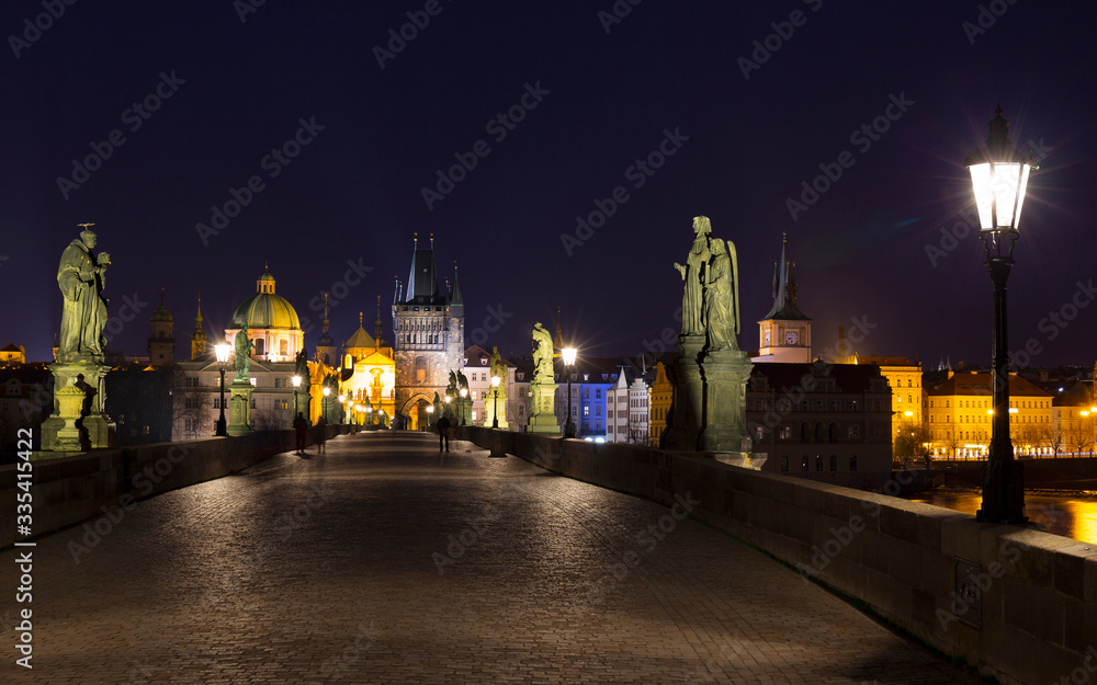 Night colorful Prague Old Town with Bridge Tower and St. Francis of Assisi Cathedral from Charles Bridge with its baroque Statues without People at the time of Coronavirus, Czech republic Night colorful Prague Old Town with Bridge Tower and St. Francis of Assisi Cathedral from Charles Bridge with its baroque Statues without People at the time of Coronavirus, Czech republic