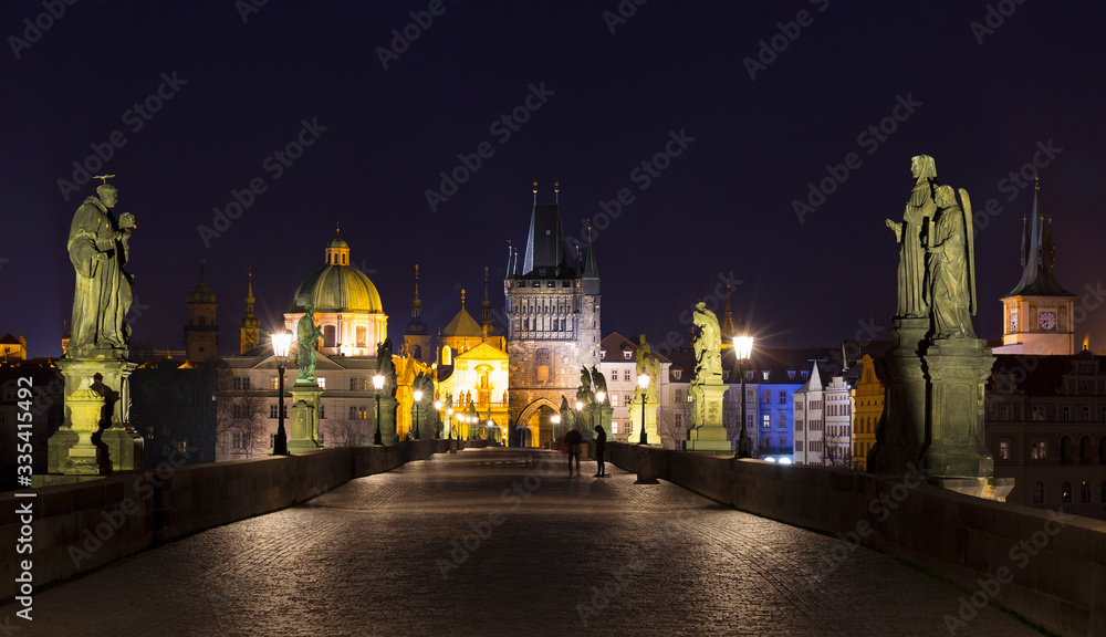 Night colorful Prague Old Town with Bridge Tower and St. Francis of Assisi Cathedral from Charles Bridge with its baroque Statues without People at the time of Coronavirus, Czech republic Night colorful Prague Old Town with Bridge Tower and St. Francis of Assisi Cathedral from Charles Bridge with its baroque Statues without People at the time of Coronavirus, Czech republic