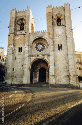 Facade of Santa Maria Maior, romanesque medieval cathedral of Lisbon in Alfama neighborhood in morning sunlight, Portugal