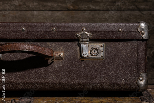 Cropped photo of a vintage leather suitcase on wooden background