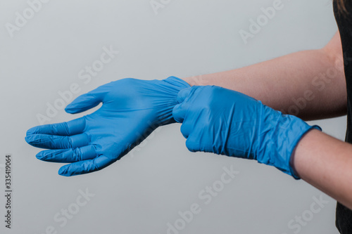 girl puts on protective gloves during the coronavirus epidemic. use of protective gloves for epidemics. protective measures for the epidemic of coronavirus covid-19