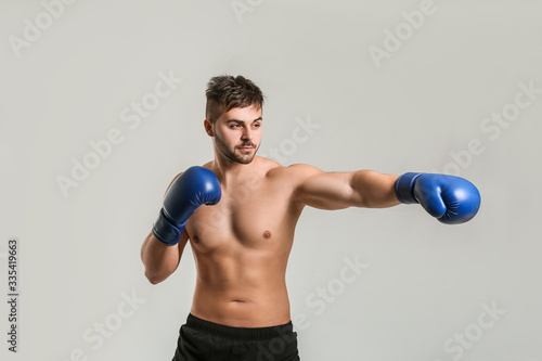 Sporty male boxer on grey background © Pixel-Shot