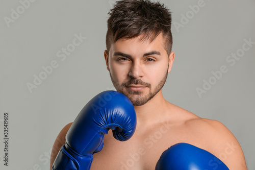 Sporty male boxer on grey b...