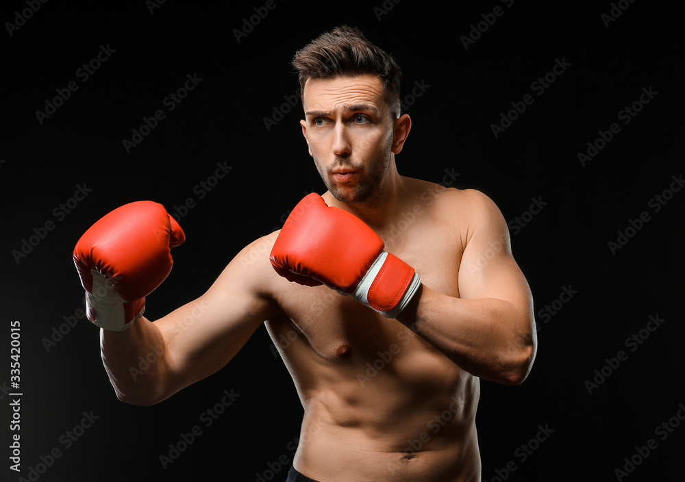 Handsome young boxer on dark background