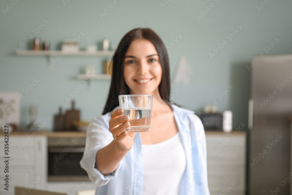 Beautiful young woman drinking water in kitchen Beautiful young woman drinking water in kitchen