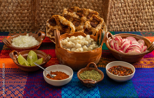 
Typical Mexican dish, white Pozole with chicken meat, and with the additional ingredients to put it, such as onion, oregano, radish, lemon, chili powder, beef greaves.