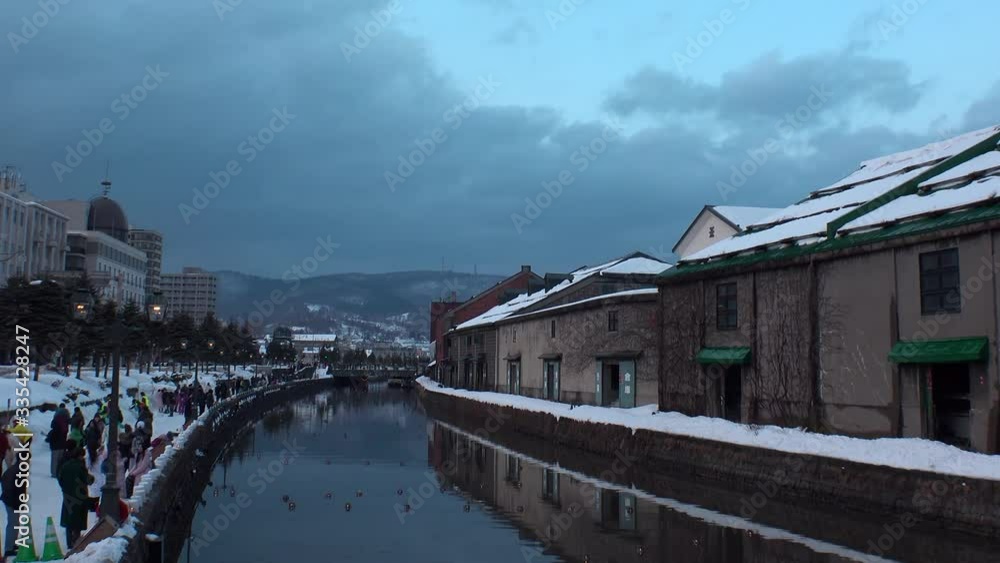 OTARU, HOKKAIDO, JAPAN - FEBRUARY 2020 : Scenery of OTARU CANAL in winter snow season. Popular tourist destination for Japanese and foreign visitors. Time lapse shot sunset to night. OTARU, HOKKAIDO, JAPAN - FEBRUARY 2020 : Scenery of OTARU CANAL in winter snow season. Popular tourist destination for Japanese and foreign visitors. Time lapse shot sunset to night.