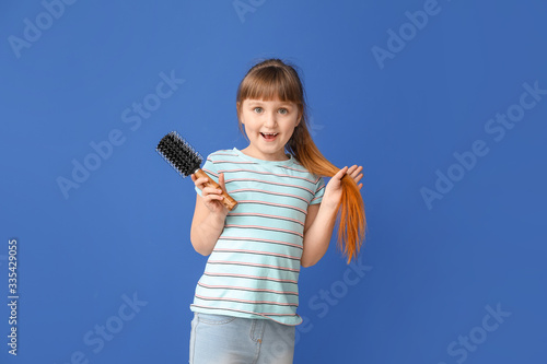 Little girl with hair brush...