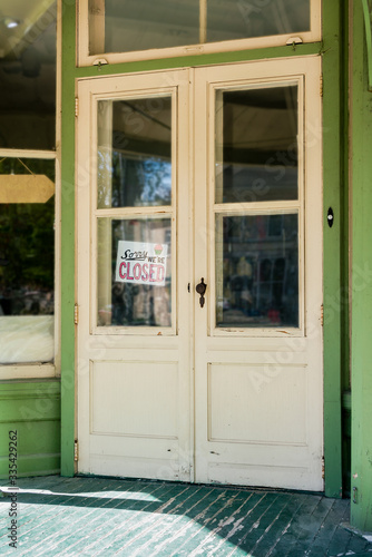 Sorry we're closed - vintage sign through the glass of store front window, of old doorway © BlokPhoto