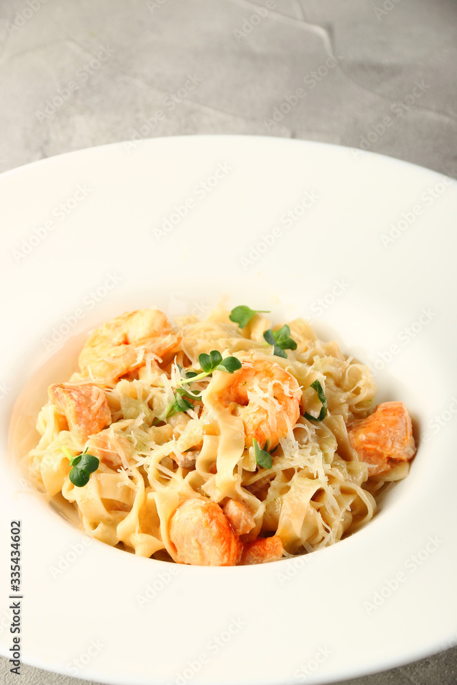 pasta with seafood closeup. pasta with shrimp and salmon in white plate