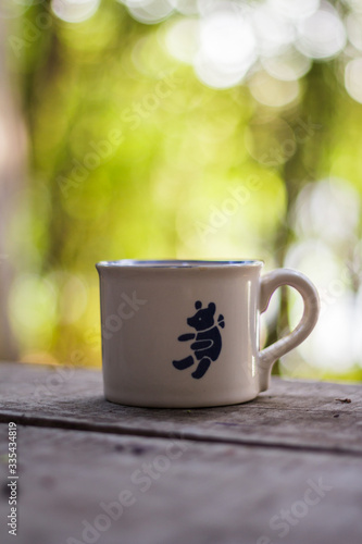 Nice coffee cup in a wooden table with nature background