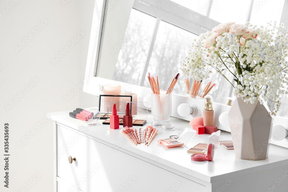 Set of decorative cosmetics on table of makeup artist in room Set of decorative cosmetics on table of makeup artist in room
