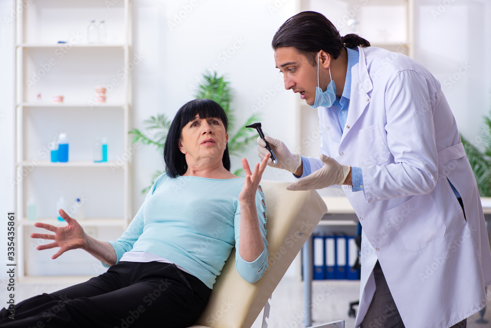 Old woman visiting young doctor laryngologist Old woman visiting young doctor laryngologist
